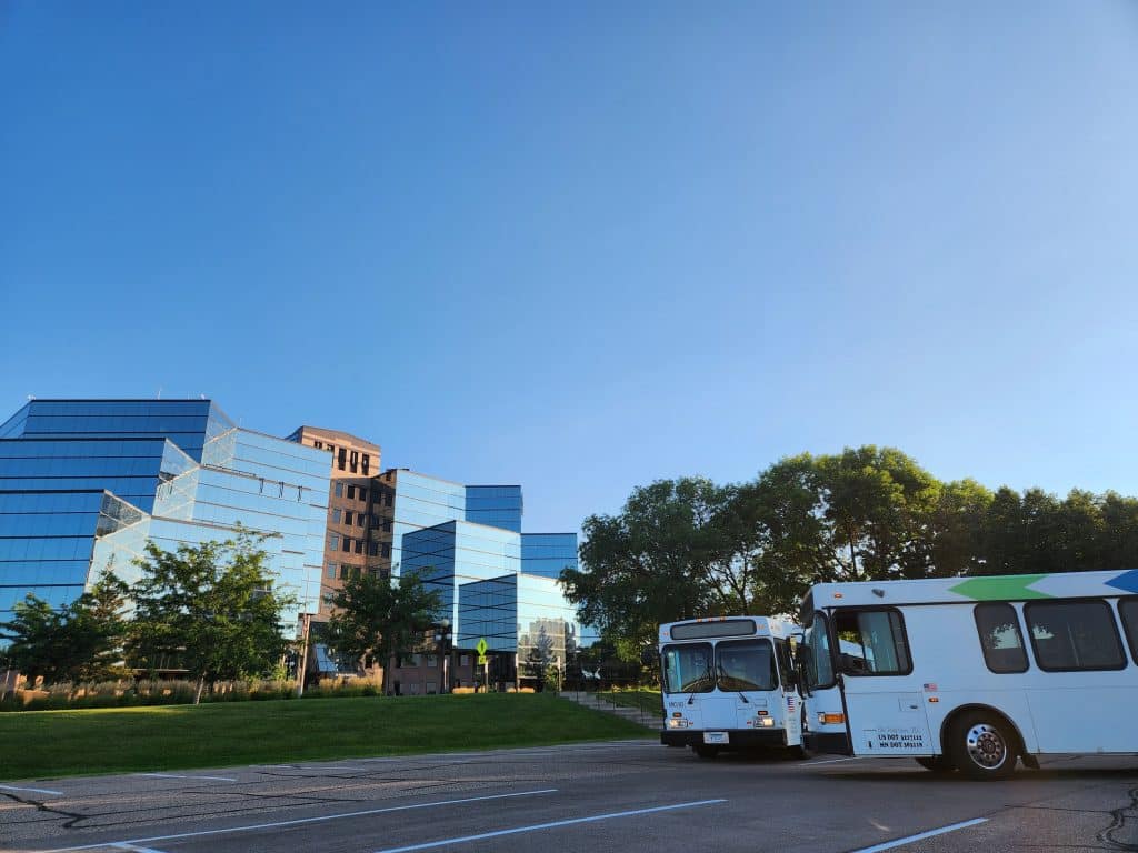 Buses parked near modern glass buildings