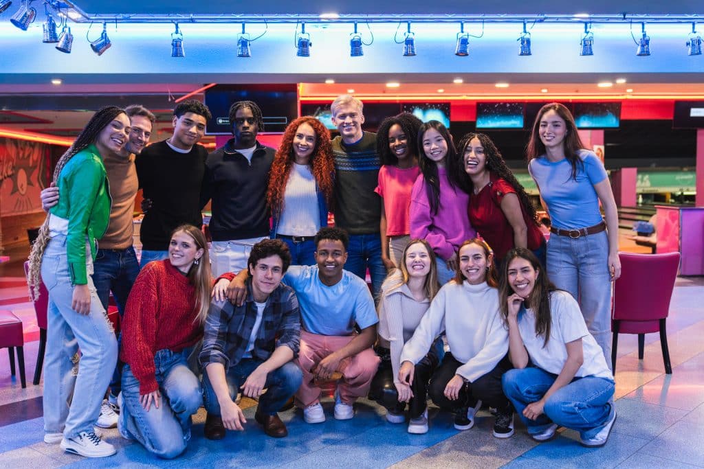 group of diverse friends enjoying bowling alley and arcade games